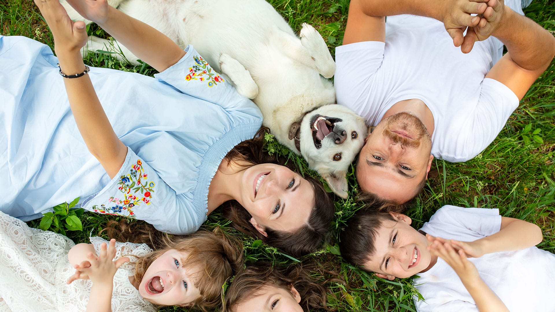 Happy Family with Dog in Green Grass
